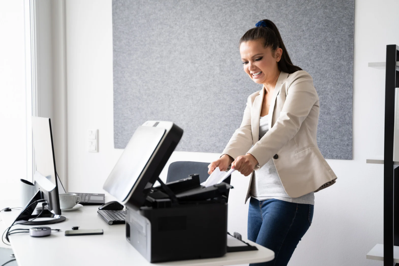 Woman trying to pull out paper jam